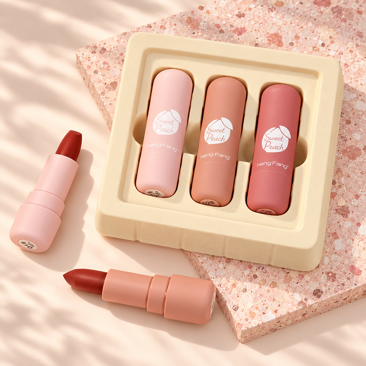 Sweet Peach lipsticks on a blush studio background